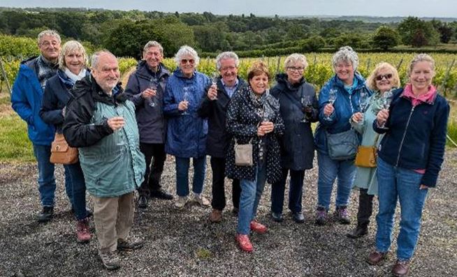 Ringmer u3a, photograph of wine appreciation group members holding wine glasses and smiling outdoors