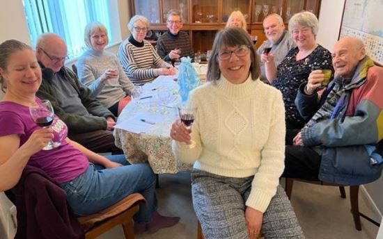 photograph of Ringmer u3a wine appreciation group members sitting, holding glasses and smiling