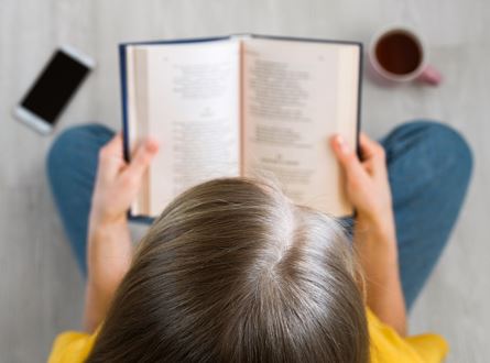 woman sitting reading a poem from a book